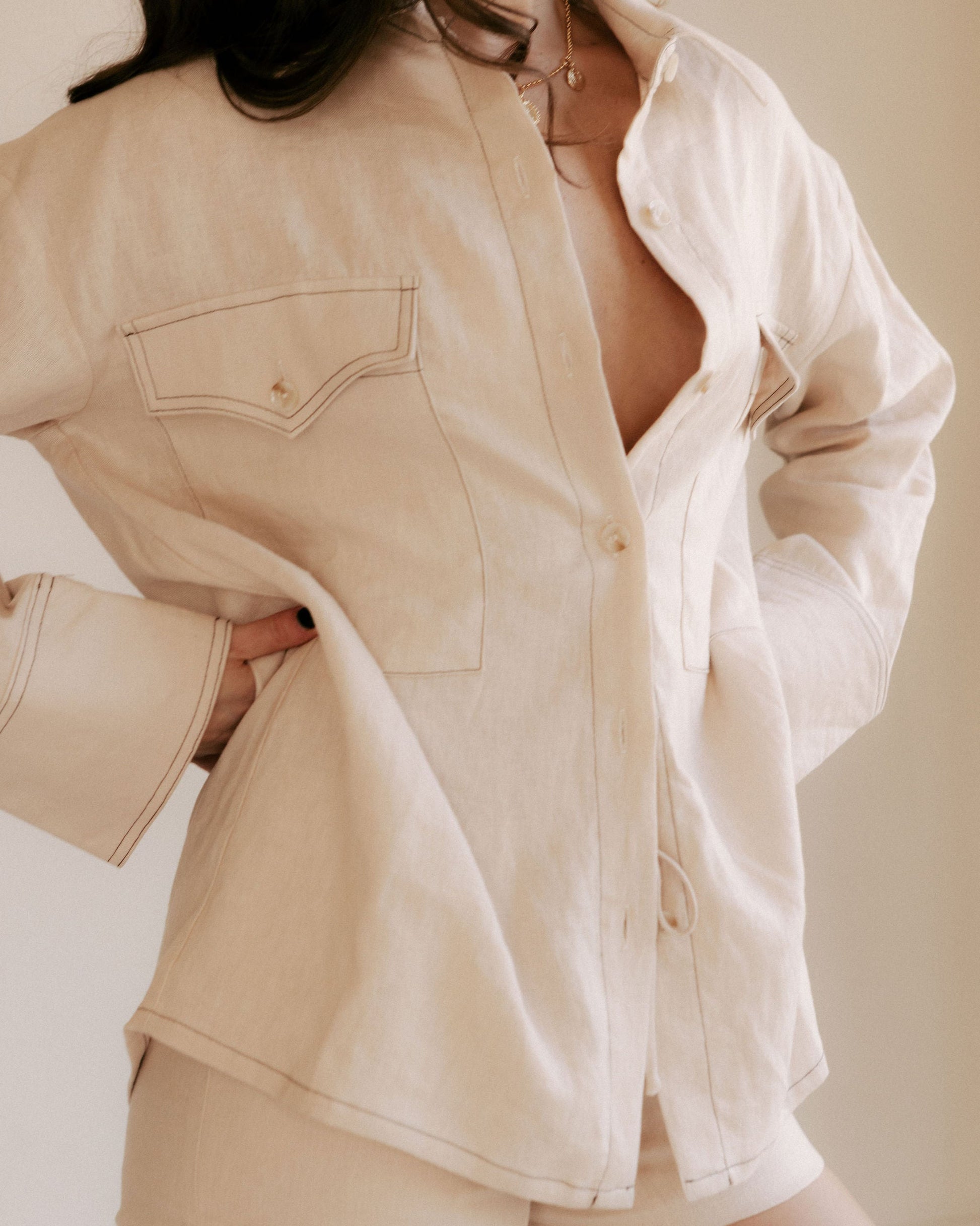 Person wearing a beige top and shorts on a plain background